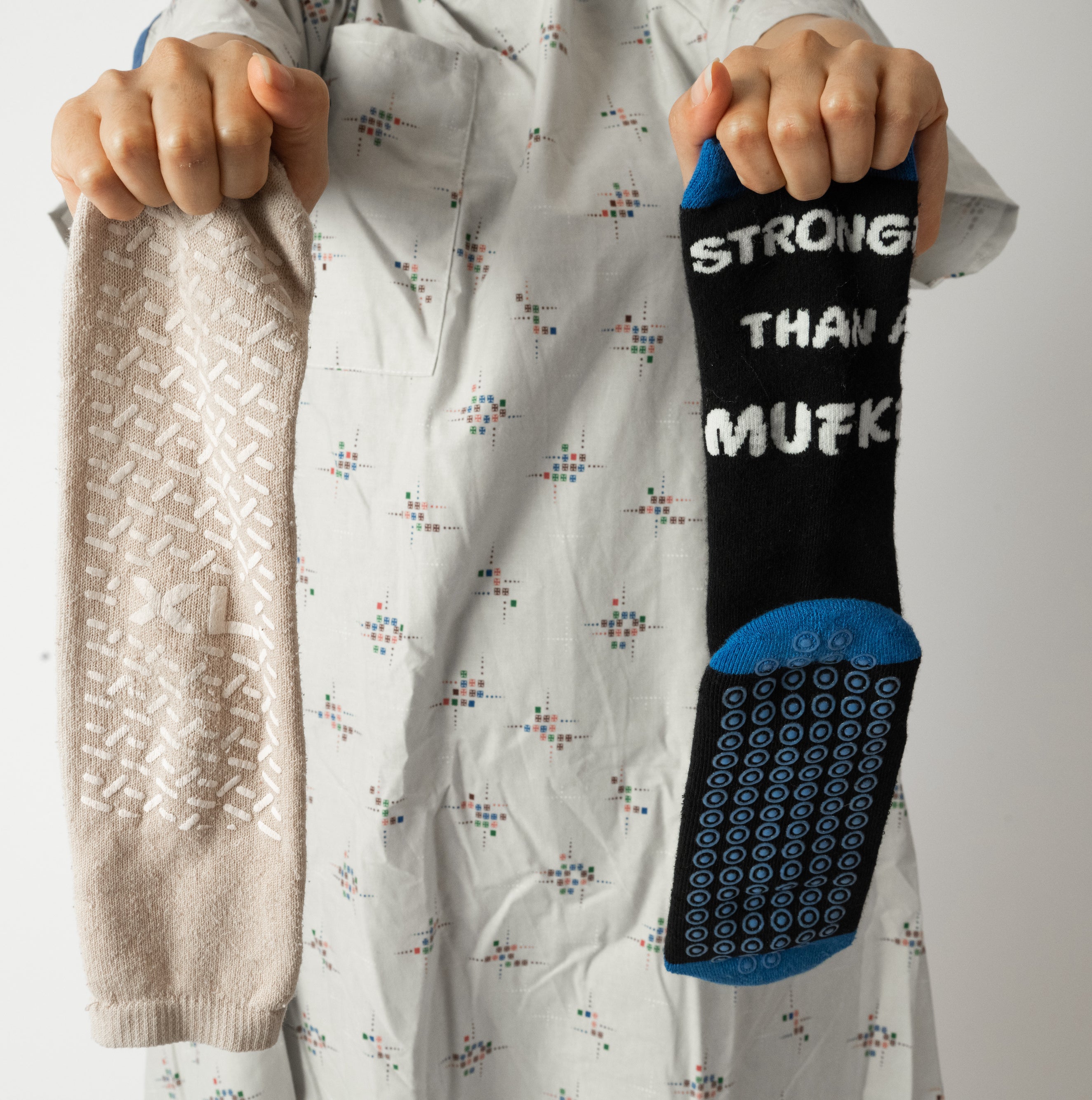 Hospital patient holding up new hospital grip socks that say "stronger than a mufkr", ideal gift for patient in recovery