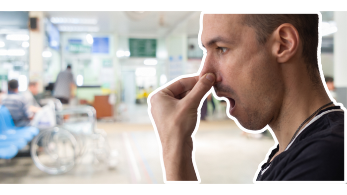 a man covering his nose in a hospital