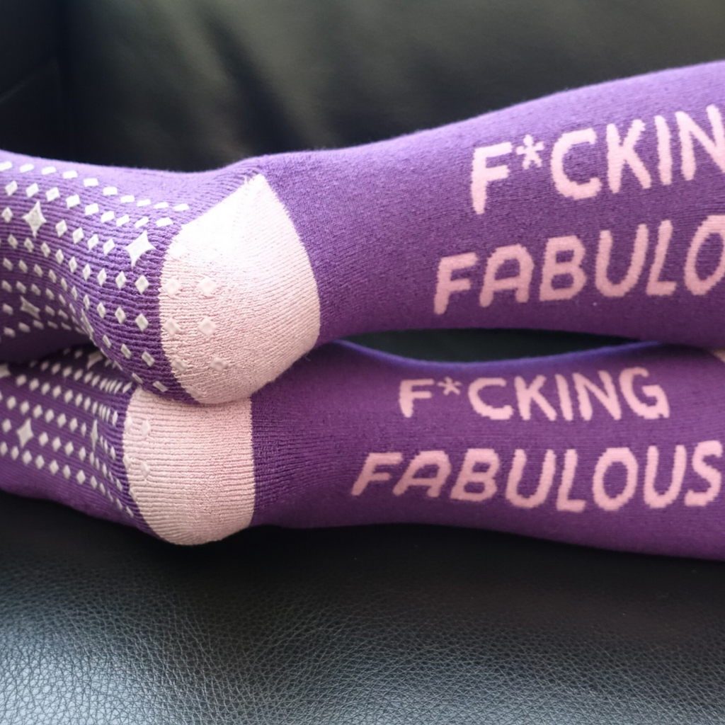F*cking fabulous' hospital sock worn by someone lounging on a couch