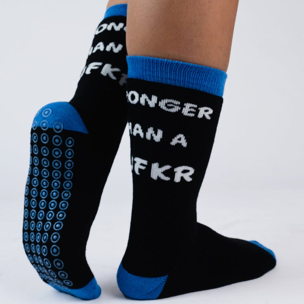 Blue grippy socks for hospital use with 'stronger than a mufkr' message, shown on someone's feet.